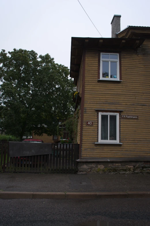 a building with wood trim and a wooden picket fence