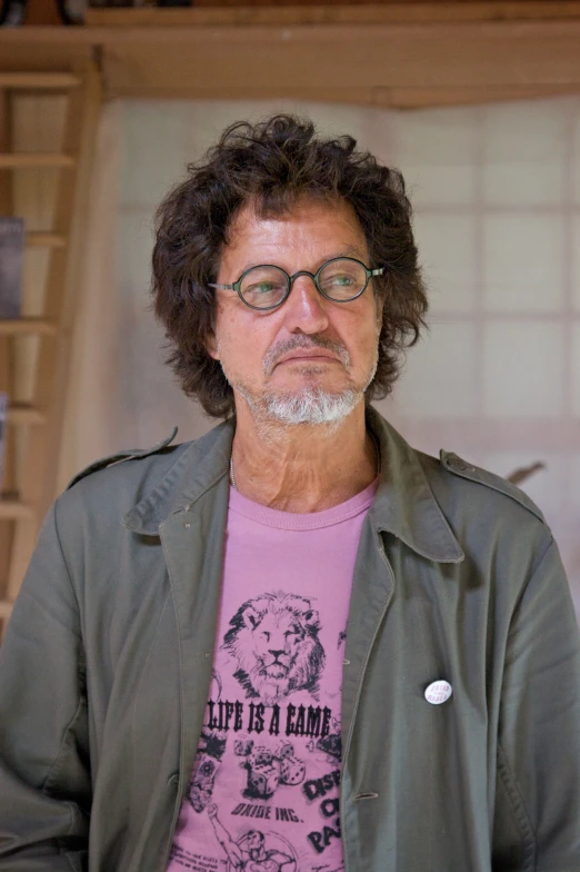 a man wearing glasses standing next to a pizza box