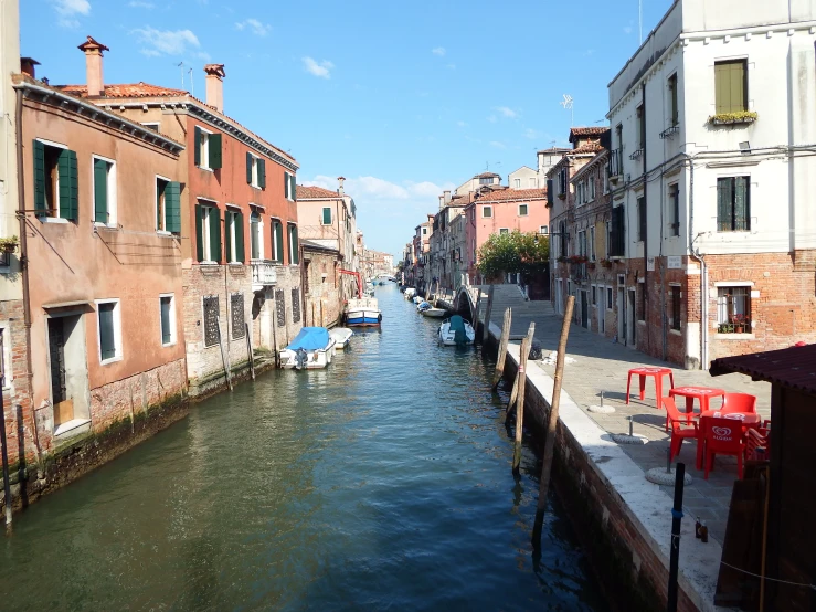 several boats parked on the side of a small canal