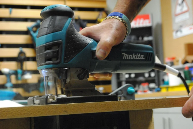 a hand sanding wood with a sanders dner