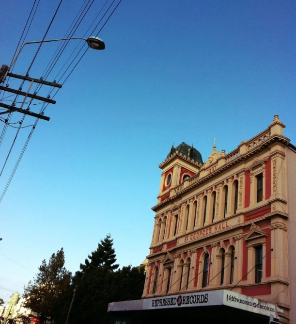 an old pink building sits under the blue sky