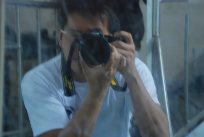 a man holds his camera up in front of him