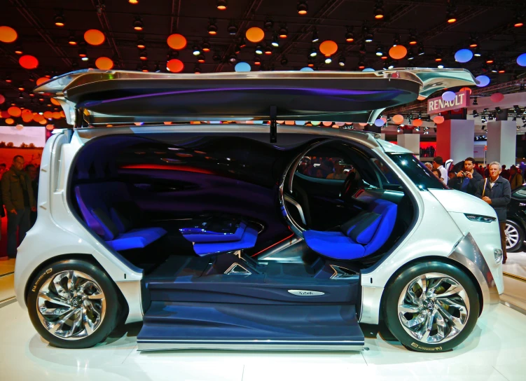 a car with open doors is on display at a show