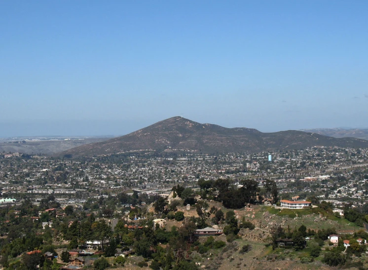 a panoramic view of a small city, mountains and hills