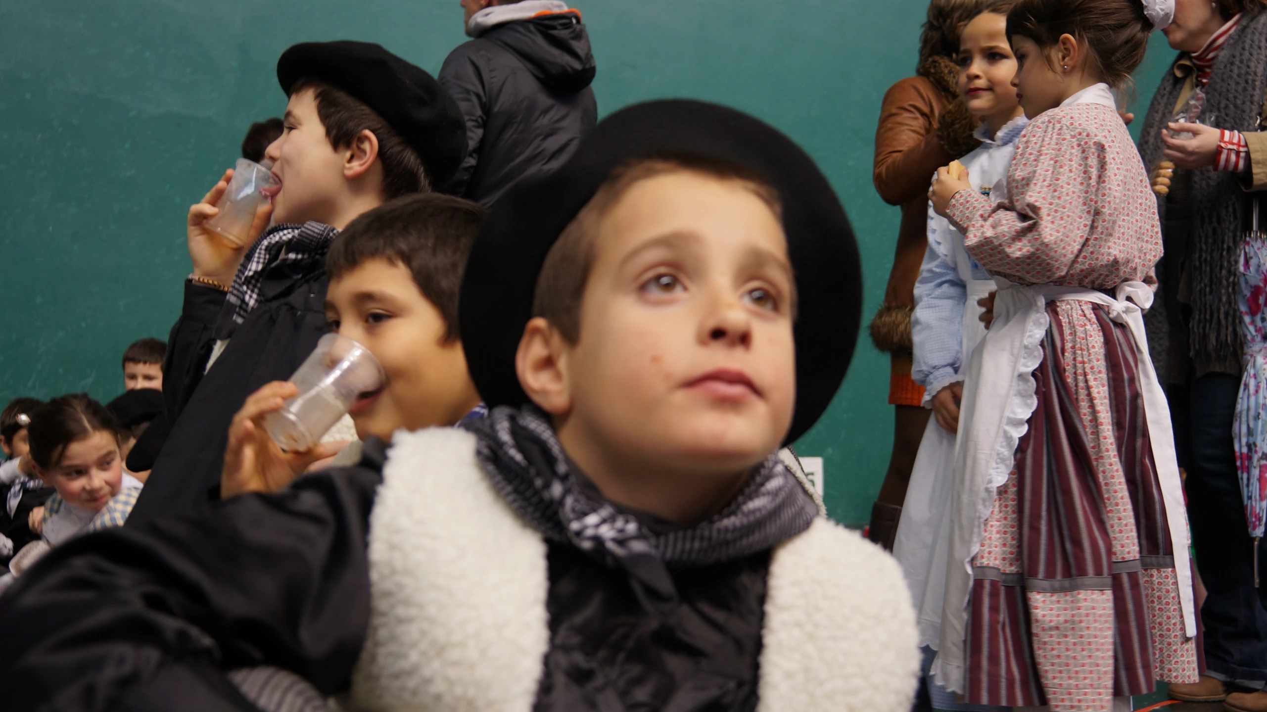 there are many children standing outside wearing hats and blankets