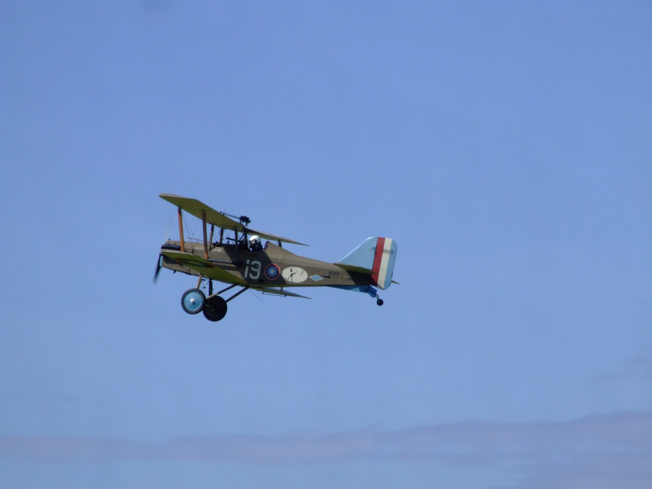 a single engine plane with a propeller flying in the sky