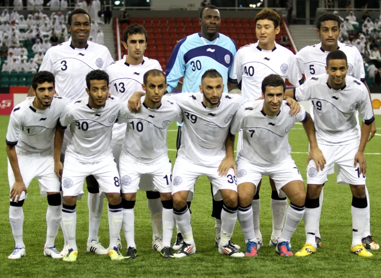 a group of men posing for a po on a soccer field