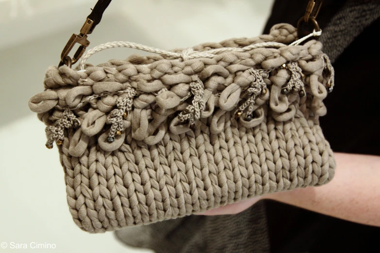 the small handbag is made of yarn and beads