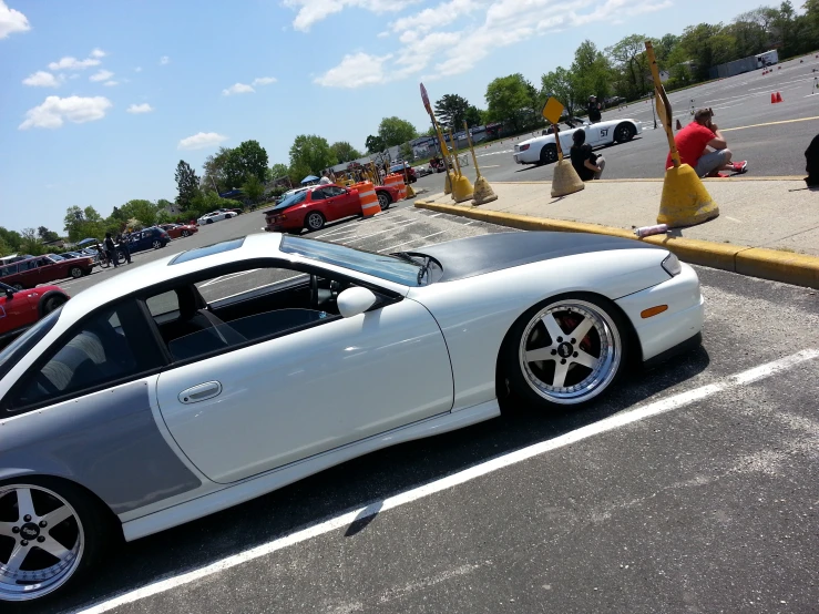 a white sports car is parked in the parking lot