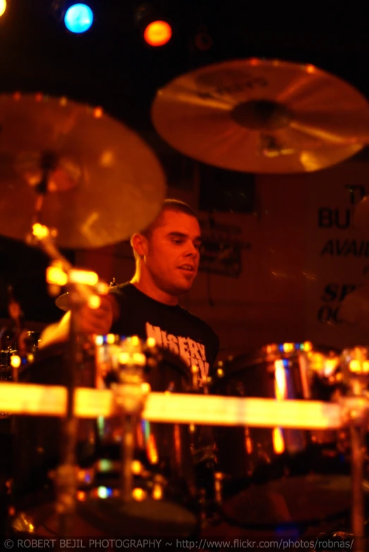 a man is playing drums while seated at the top of a set