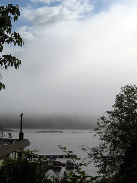 a foggy sky and boats in the water