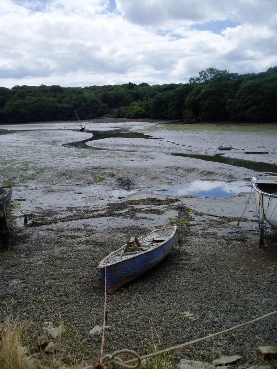 a boat is sitting on the bank in a muddy area