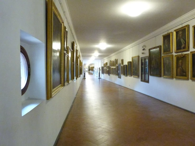 a long hallway with paintings hanging on the walls