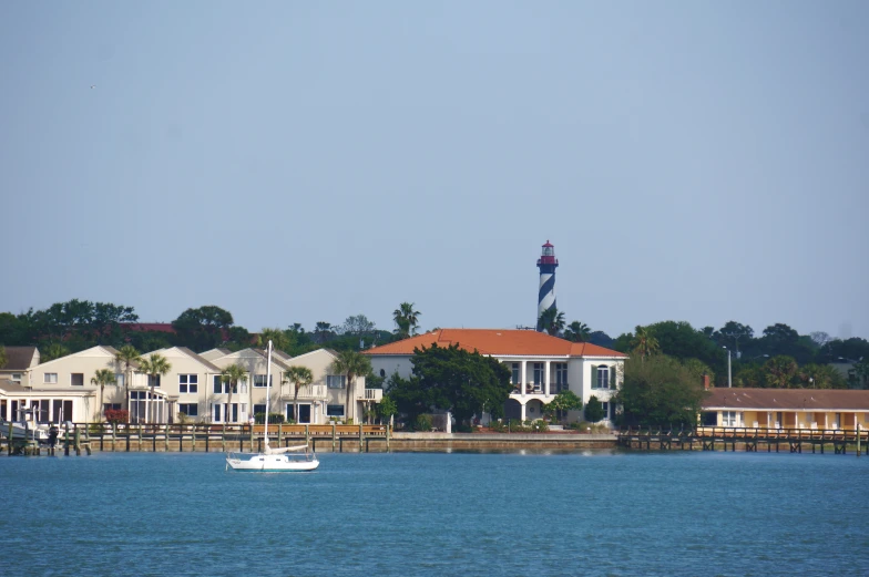 a white boat floating down a river past a resort