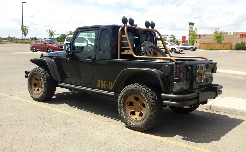 an jeep with the top up parked in a parking lot