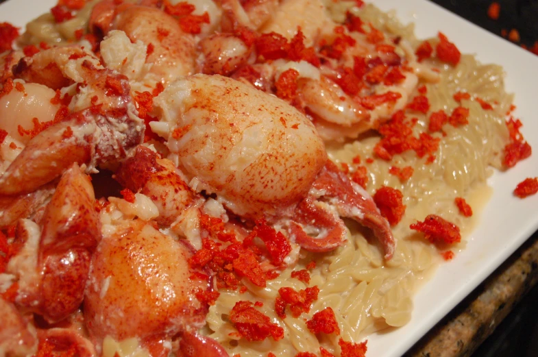 a plate topped with pasta covered in chicken and pepper