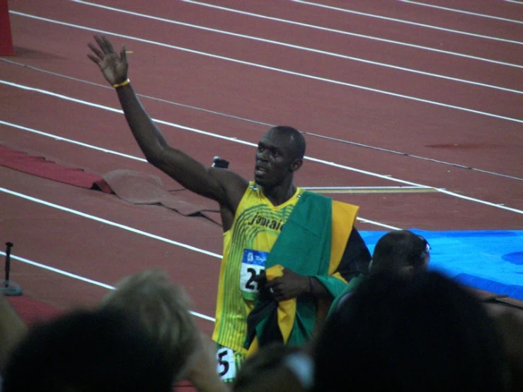 an athlete waves his arms while crossing the line