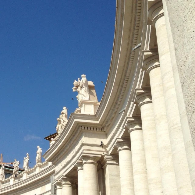 a white building with statues on it and windows