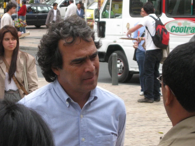 a man looks off into the distance at people walking and sitting