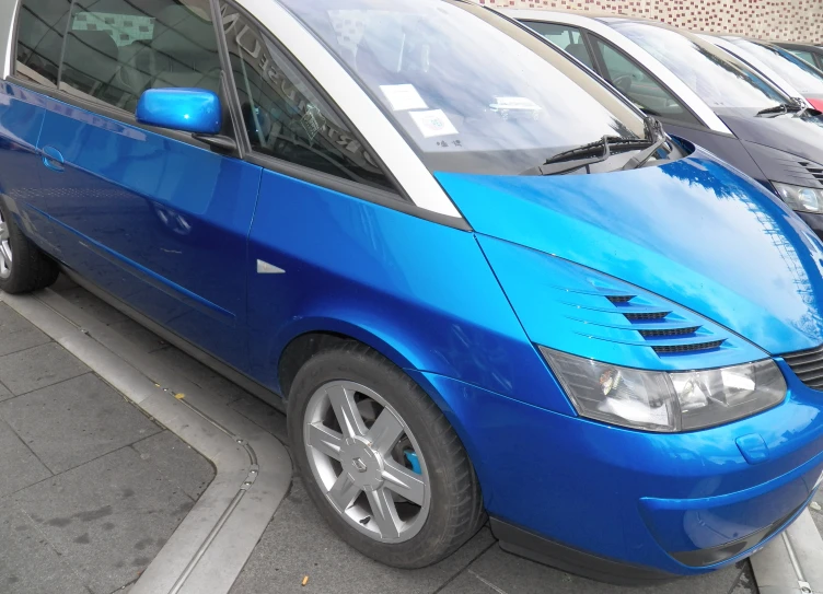 a blue van is parked next to several other cars