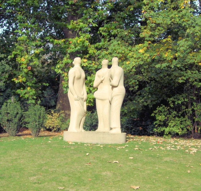 there are two statues in a garden near the trees