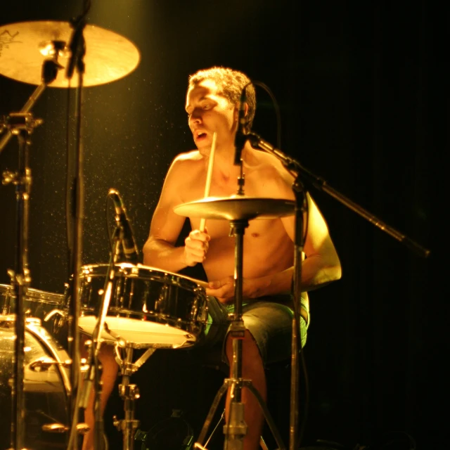 a man sitting in front of a drum kit