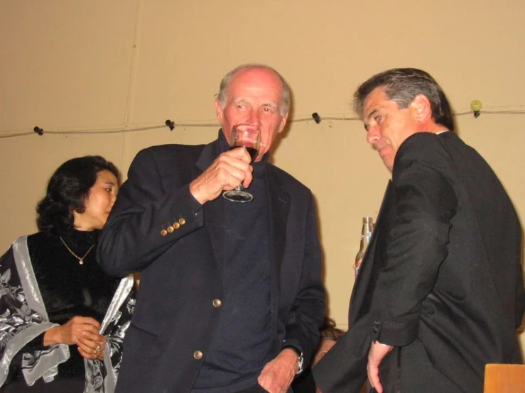 three people are enjoying drinks at a function