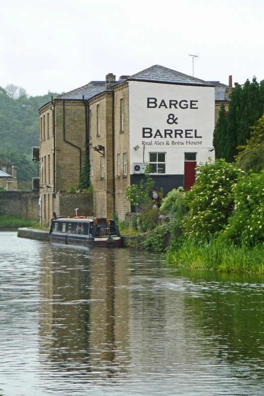 boat passing through a canal in front of a bar and barrel