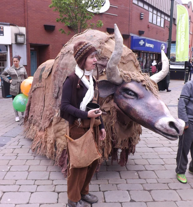 a woman dressed as a cow walks down a busy city street