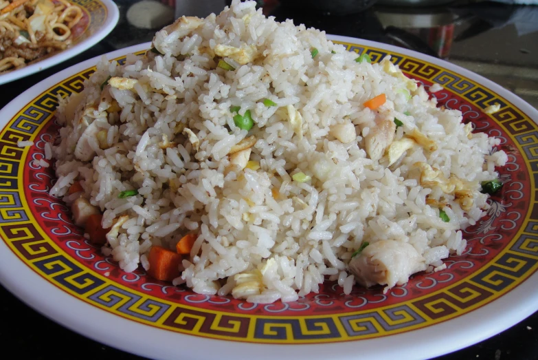 a plate of rice with carrots and peas on it