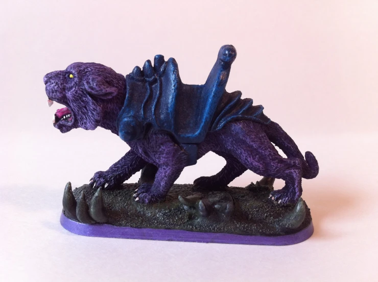a small, purple dinosaur with a green head and black arms