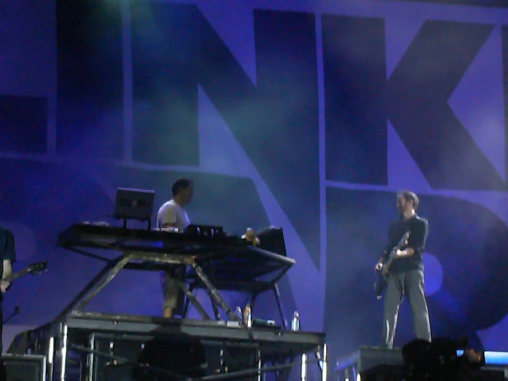 three male djs playing their equipment on stage