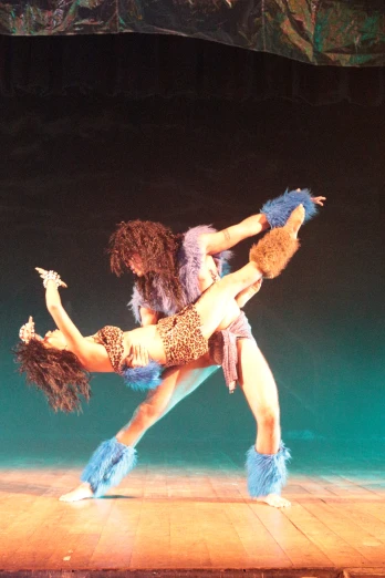 two women in costume on stage performing an intense dance