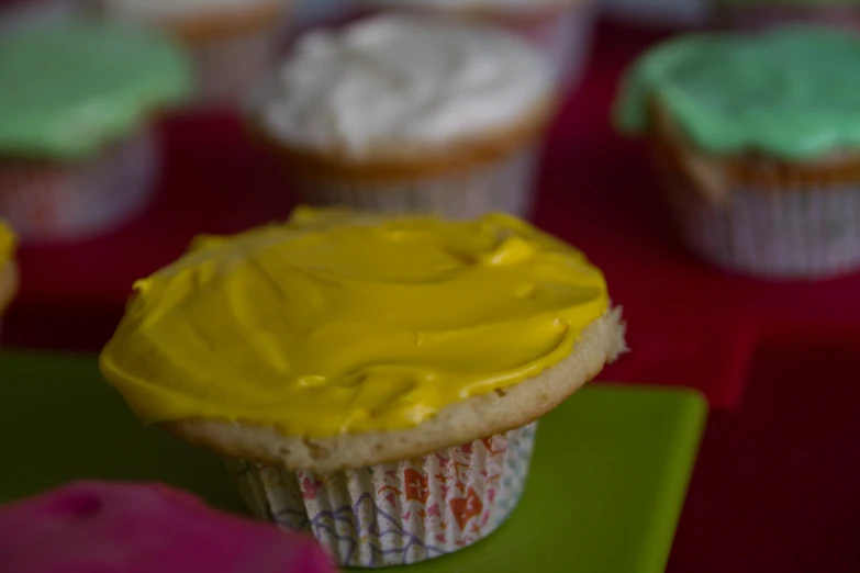 a cupcake with yellow icing and green frosting