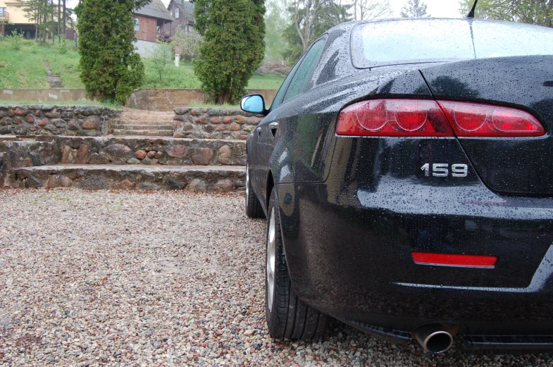 a large black car sitting outside of a house