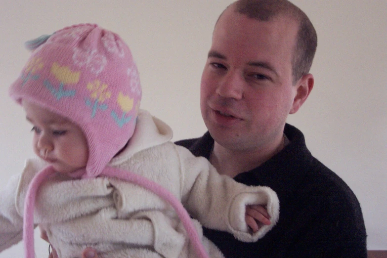 a baby girl being held by her father