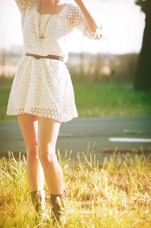 woman in a white dress walking in grassy field