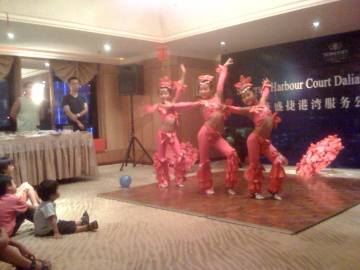 several people on stage performing a performance with red costumes