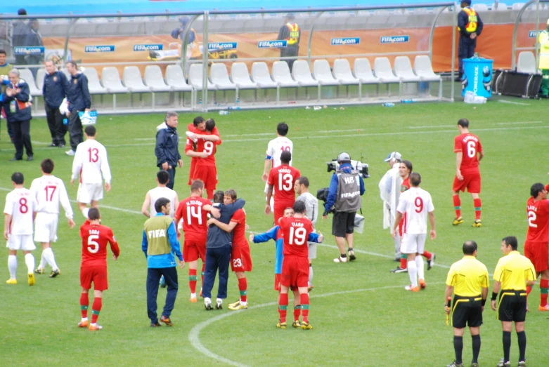 several players of the soccer team on the field shaking hands with each other