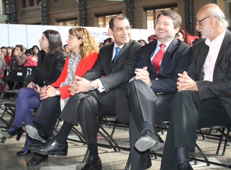 several people are sitting on chairs in front of each other