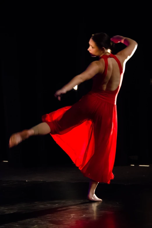 a woman in a red dress dancing on stage