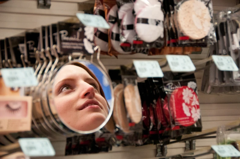 a woman looking out into a store through a magnifying glass