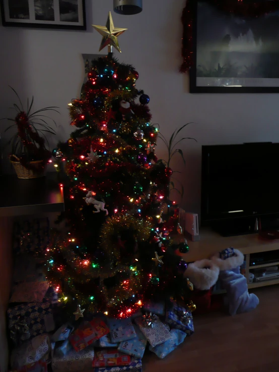 christmas tree, presents and stuffed animals are piled up on the floor