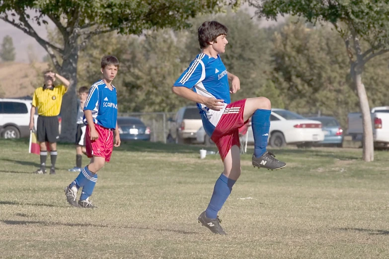 young children playing a game of soccer on the field