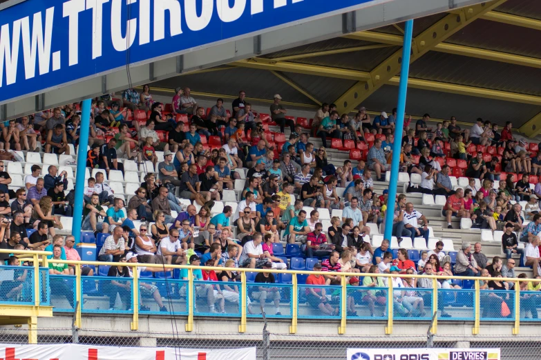 many people are in stands with one person holding a red umbrella