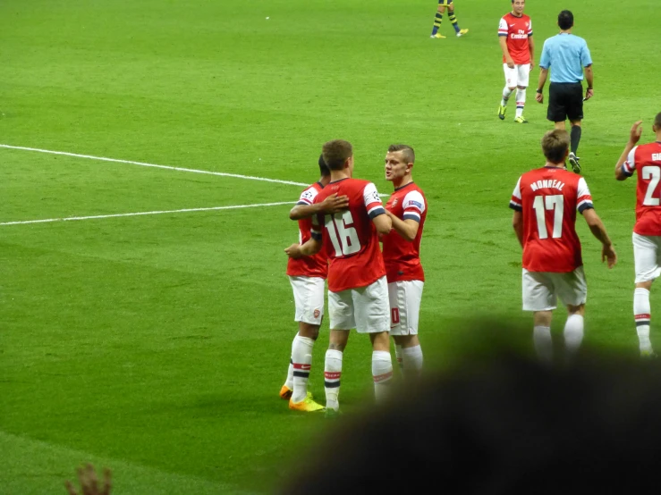 a group of soccer players are standing on the field