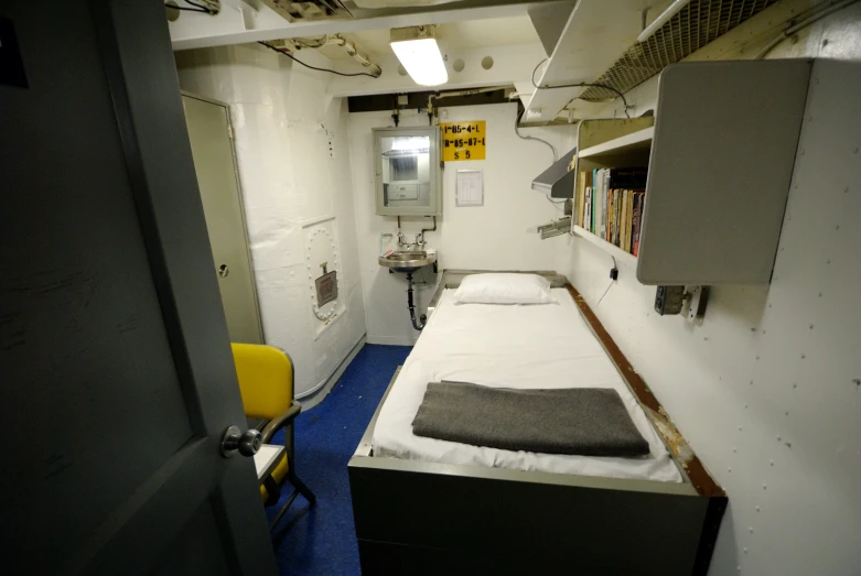 a small bedroom with a white bed and desk