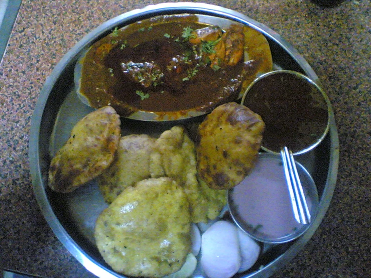 a variety of meats with sauce and condiments on a plate