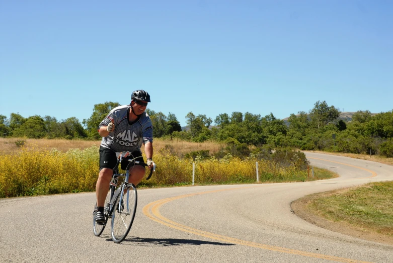 a man riding a bike down the middle of the road