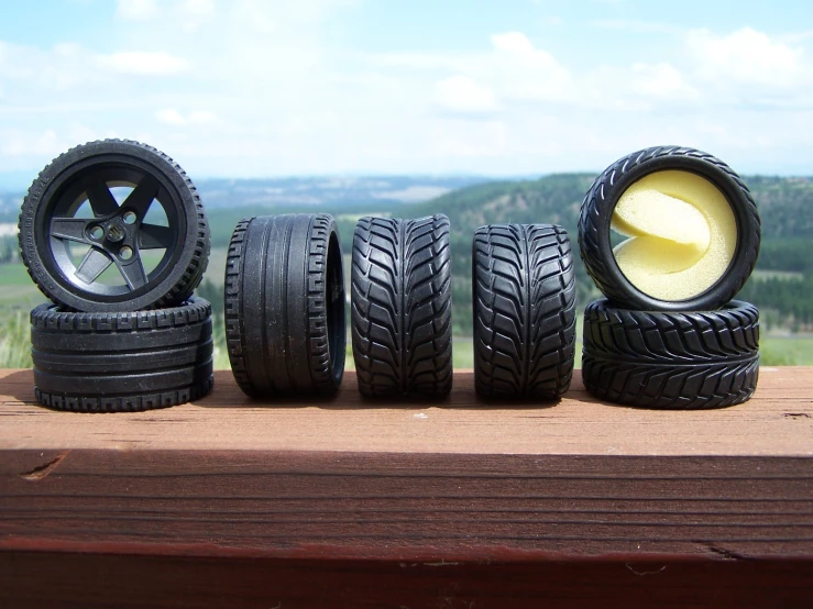 an assortment of tires are sitting on the edge of a porch